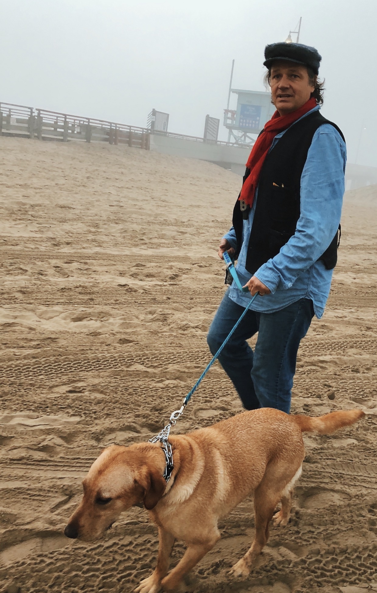 Timothy walking a dog on a foggy beach